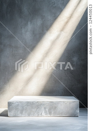 A textured concrete backdrop features a strong spotlight that casts a soft halo of light, enhancing the deep cinematic contrast and providing an elegant industrial feel, perfect for creative displays 124450013