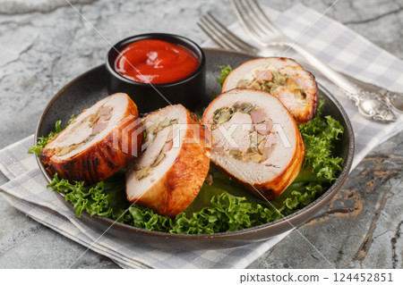 Festive sliced turkey fillet roll with bacon, onions and mushrooms served with ketchup close-up in a plate. Horizontal Festive sliced turkey fillet roll with bacon, onions and mushrooms served with ketchup close-up in a plate. Horizontal 124452851