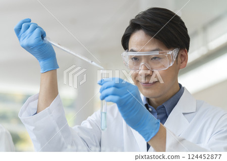 A man in a white coat working with a test tube, experiment image 124452877