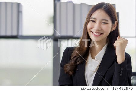 A woman cheering in a business suit A woman cheering in a business suit 124452979