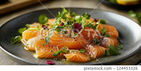 Thinly sliced salmon carpaccio appetizer garnished with fresh microgreens, sesame seeds, and a drizzle of olive oil Thinly sliced salmon carpaccio appetizer garnished with fresh microgreens, sesame seeds, and a drizzle of olive oil 124453326
