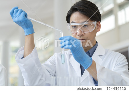 A man in a white coat working with a test tube, experiment image A man in a white coat working with a test tube, experiment image 124454310