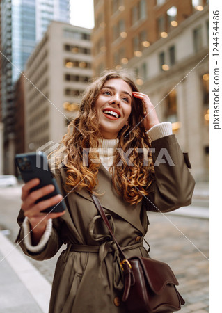 Portrait of happy woman with smartphone in the street city. Concept of blogging, technology, weekend 124454486