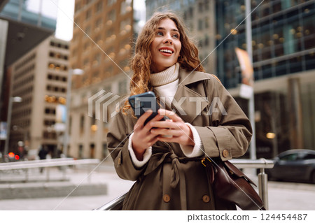 Portrait of happy woman with smartphone in the street city. Concept of blogging, technology, weekend 124454487