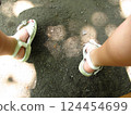 A selfie taken by a toddler showing sunlight filtering through the trees and a child's feet in sandals 124454699