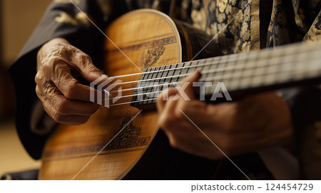 A craftsman playing the shamisen in a Japanese-style room A craftsman playing the shamisen in a Japanese-style room 124454729