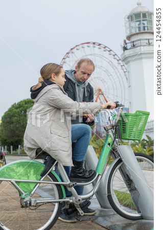 Father and daughter rent a bike Father and daughter rent a bike 124454855