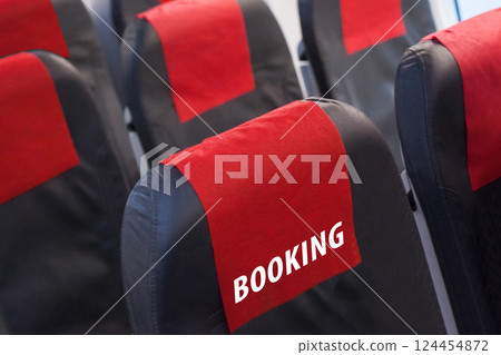 Booking flight and travel concept. Empty seat in plane with booking inscription 124454872