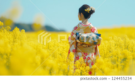 A woman in a kimono walking through a rapeseed flower field 124455234