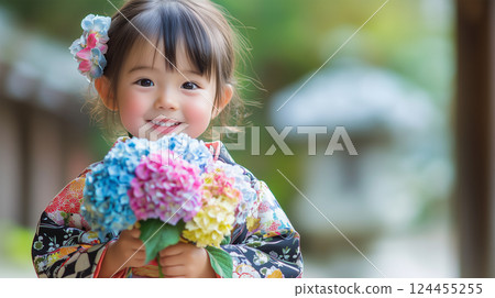 A woman holding a hydrangea in her small hands and showing a pure smile 124455255