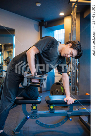 Man doing muscle training with dumbbells 124455303