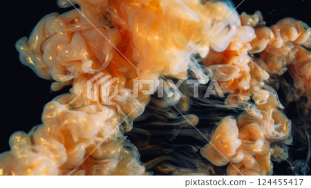 Glitter splash. Fume paint explosion. Orange beige vapor stream swirl mix shape on black background. Blur color haze abstract shiny dye wave spill. 124455417