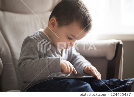 Little boy using a digital tablet sit on the living room 124455427