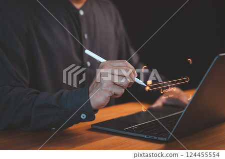 Close-up of a person using a pen with a laptop, highlighting a glowing loading bar and digital interface, representing technology, progress, and innovation. 124455554