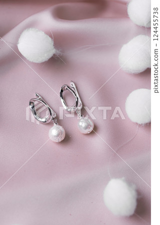 Silver earrings made of natural pearl. Natural mineral texture jewelry. Bijouterie and handmade accessories top view elegant background Silver earrings made of natural pearl. Natural mineral texture jewelry. Bijouterie and handmade accessories top view elegant background 124455738