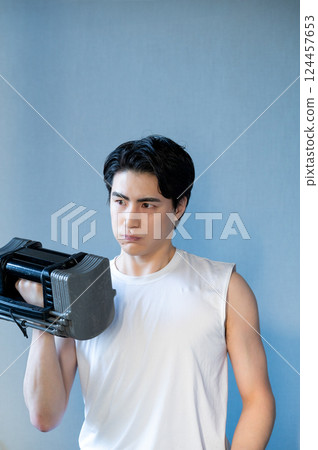Man doing muscle training with dumbbells Man doing muscle training with dumbbells 124457653