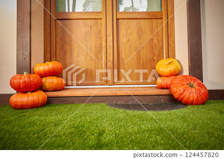 Two stacks of large orange pumpkins At the door of the house. Autumn harvest and home decor for Halloween 124457820