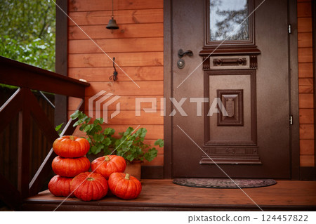 Halloween home decor. Stack pumpkins Near the door of the house. Autumn harvest Halloween home decor. Stack pumpkins Near the door of the house. Autumn harvest 124457822