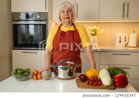 Senior woman preparing vegetables for cooking in the kitchen Senior woman preparing vegetables for cooking in the kitchen 124458347