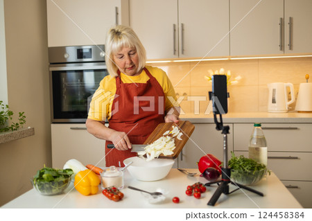 Senior Woman Mixing Ingredients in Kitchen for Healthy Meal Preparation 124458384