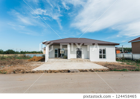 New house under construction on suburban street with blue sky background. Real estate development, investment, and residential planning New house under construction on suburban street with blue sky background. Real estate development, investment, and residential planning 124458465