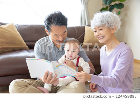祖父母和孫輩閱讀圖畫書 124459883