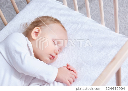 The baby sleeps safely and sweetly wooden crib on a terry sheet elastic band. The baby sleeps safely and sweetly wooden crib on a terry sheet elastic band. 124459904