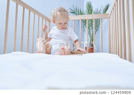 Baby is playing cubes in the crib. Copy space for text or children's product. 124459909