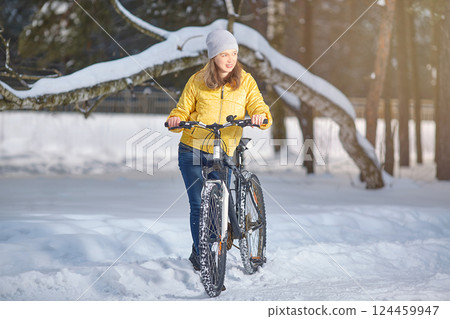 Woman with a bicycle in winter. Winter sports. Active recreation 124459947
