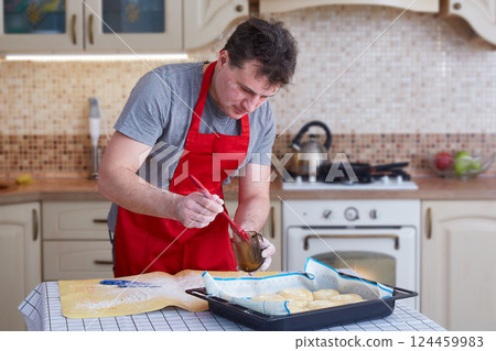 A man at home in the kitchen bakes pies A man at home in the kitchen bakes pies 124459983