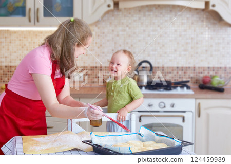 Mom and little daughter cook pies in the kitchen at home 124459989