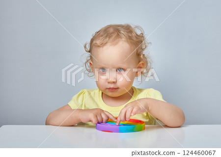 Popular Anti stress toy Pop It. Child Playing With The Pop It Fidget Toy. Happy childhood, popular educational games. Popular Anti stress toy Pop It. Child Playing With The Pop It Fidget Toy. Happy childhood, popular educational games. 124460067
