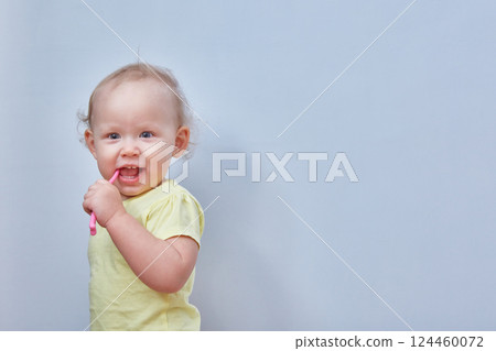 Toddler brushes his teeth against a light background. Copy space Toddler brushes his teeth against a light background. Copy space 124460072