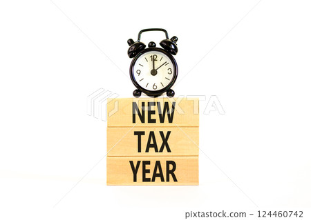 New tax year symbol. Concept words New tax year on beautiful wooden blocks. Beautiful white background. Black alarm clock. Business new tax year concept. Copy space. 124460742