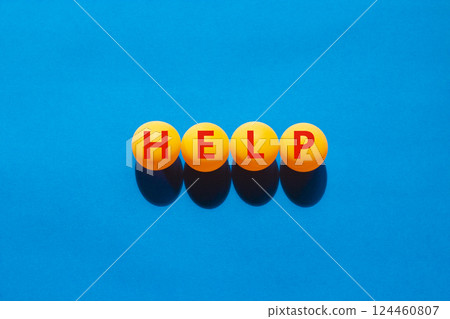 Help symbol. Concept word Help on beautiful yellow ping pong balls. Beautiful blue table blue background. Business, lifestyle, support and help concept. Copy space. 124460807