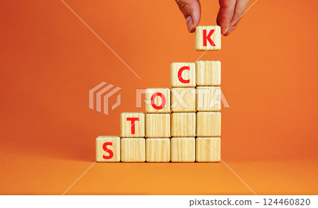 Stock symbol. Concept word Stock on beautiful wooden blocks. Beautiful orange table orange background. Businessman hand. Business lifestyle stock concept. Copy space. Stock symbol. Concept word Stock on beautiful wooden blocks. Beautiful orange table orange background. Businessman hand. Business lifestyle stock concept. Copy space. 124460820