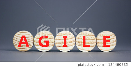 Agile symbol. Concept word Agile on beautiful wooden circles. Beautiful grey table grey background. Business flexible and agile concept. Copy space. Agile symbol. Concept word Agile on beautiful wooden circles. Beautiful grey table grey background. Business flexible and agile concept. Copy space. 124460885