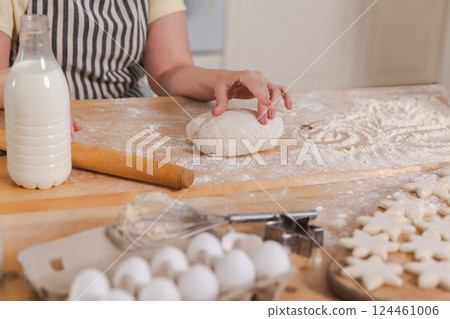 Senior woman cooking in kitchen, hands close up. Older mature lady grandmother hands knead dough bake cookies. Old grandma cook homemade food. Household housewife housework concept Senior woman cooking in kitchen, hands close up. Older mature lady grandmother hands knead dough bake cookies. Old grandma cook homemade food. Household housewife housework concept 124461006