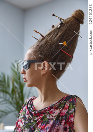 An extravagant woman in sunglasses with a strange hairstyle of long hair on her head. An extravagant woman in sunglasses with a strange hairstyle of long hair on her head. 124461288