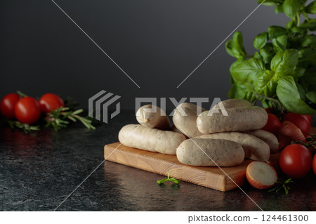 Traditional Bavarian white sausages with basil, onion, rosemary, and tomatoes. 124461300