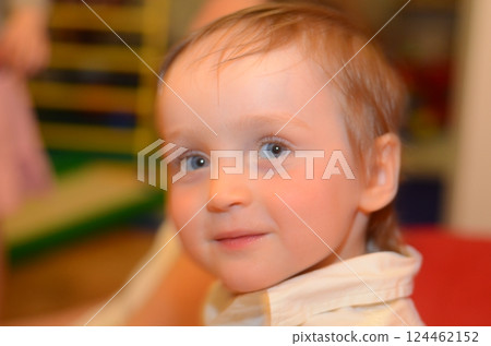 Curious Toddler with Soft Smile Looking into Camera 124462152