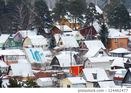 Winter wonderland in a peaceful snowy village surrounded by pine trees and serene tracks 124462477