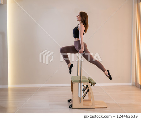 Asian woman doing pilates classic chair.  124462639