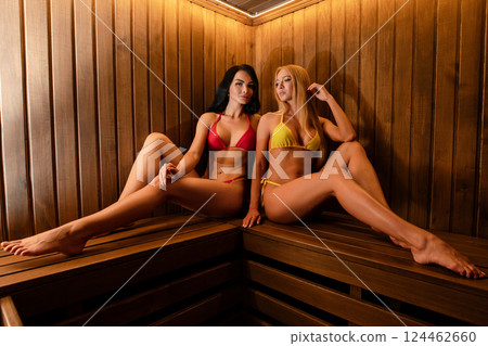 Women posing in lingerie in a sauna setting, showcasing confidence and style 124462660