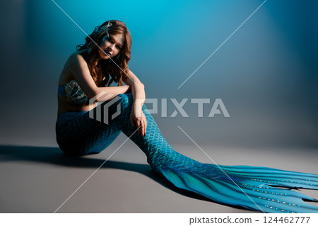 Mermaid cosplay featuring a woman in stunning body art at a studio setting 124462777