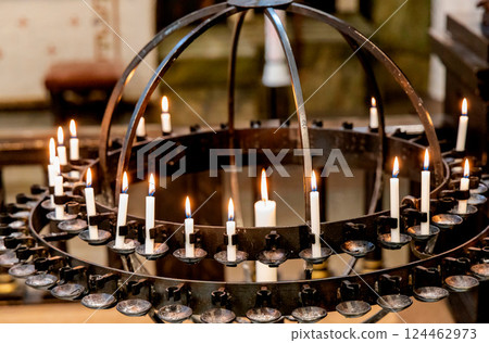 Lit candles in a candelabra in a church. Concept of spirituality 124462973