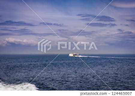 Seascape with a white ferry in the distance and waves. Seascape with a white ferry in the distance and waves. 124463007