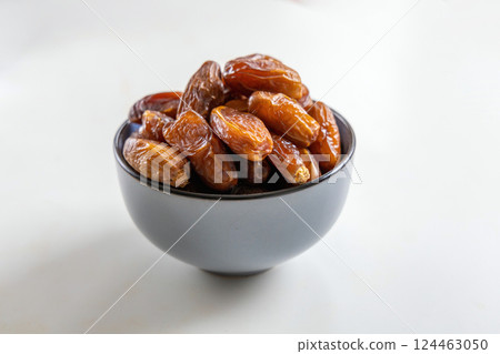 Delicious dates in a bowl on white Delicious dates in a bowl on white 124463050