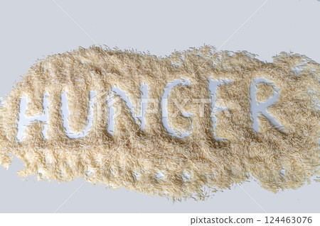 A pile of dry white rice with the word hunger written on it 124463076