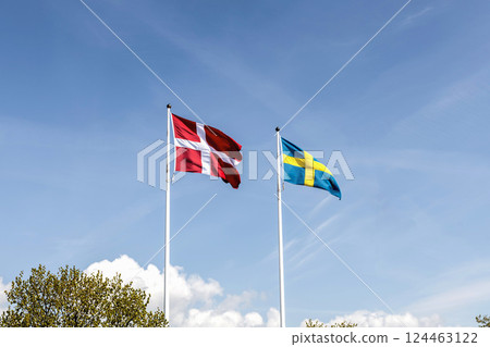 Denmark and Sweden flags against blue sky 124463122